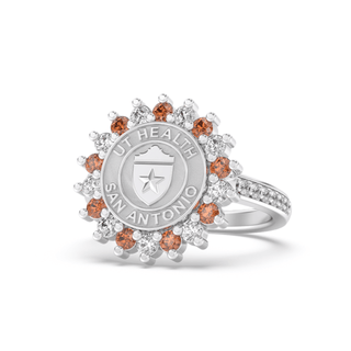 Silver class ring with a university of texas san antonio health science center seal and small orange and white stones on a white background
