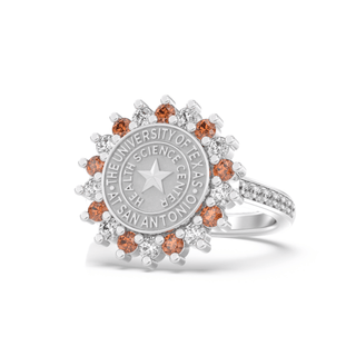 Silver class ring with a university of texas san antonio health science center seal and small orange and white stones on a white background