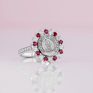 WHITE GOLD UNIVERSITY OF ARKANSAS GRADUATION CLASS RING WITH RED AND WHITE STONES AROUND OLD MAIN COLLEGE SEAL