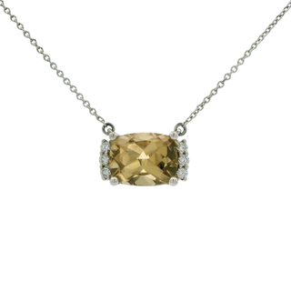 citrine pendant on a chain against a white background