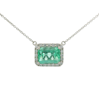 Necklace with a green emerald cut emerald pendant on a white background