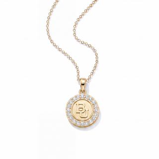 A gold pendant necklace featuring a circular medallion with a halo of clear pavé stones and an engraved 'BJ' monogram in the center, suspended from a delicate gold chain against a white background.