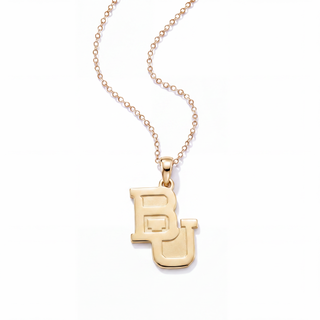 A gold pendant necklace featuring a stylized interlocking 'BU' monogram, suspended from a delicate gold chain against a clean white background.