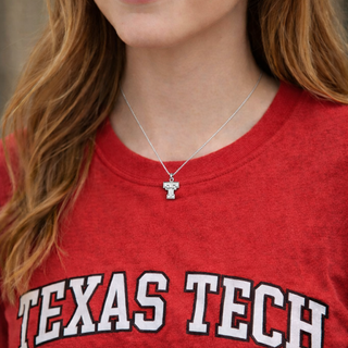 Person wearing a red 'Texas Tech' shirt with a necklace featuring a small 'TT' necklace.