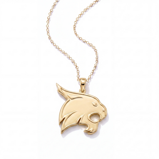 A gold-toned necklace featuring a polished bobcat head pendant on a delicate cable chain, set against a clean white background.