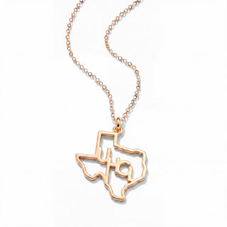 A rose gold necklace featuring a cutout pendant shaped like the state of Texas, with a small monogram 'UHCL' inside, displayed on a clean white background.