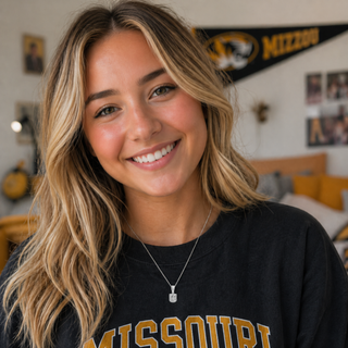 Woman wearing a black university of Missouri MU Necklace in a room with sports-themed decor.