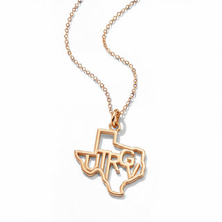 A yellow gold necklace featuring a pendant shaped like the state of Texas, with the letters 'UTRG' cut out in the center, displayed on a clean white background.
